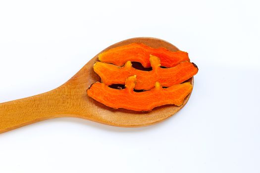 Cutting of turmeric roots on wooden spoon on white background.