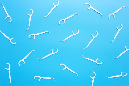 White floss toothpicks on blue background. Top view
