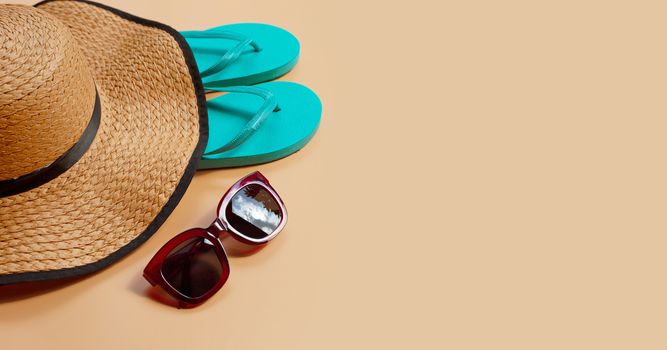 Summer hat with flip flops and sunglasses on brown background. Enjoy holiday concept. Copy space