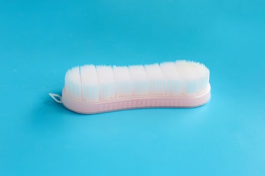 Brush for cleaning clothes on blue background.