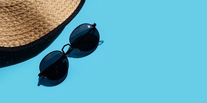 Hat with sunglasses on blue background. Enjoy summer holiday concept. Copy space