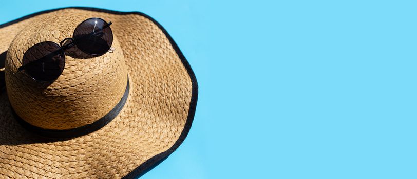 Summer hat with sunglasses on blue background. Enjoy holiday concept. Copy space