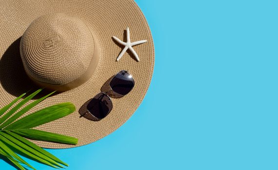 Summer hat with sunglasses on blue background. Enjoy holiday concept. Copy space