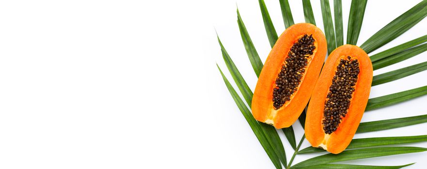 Half ripe papaya fruit on green leaves. Top view