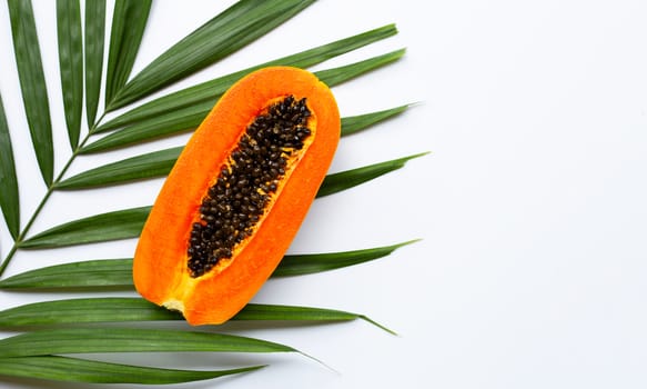 Half ripe papaya fruit on green leaves. Top view