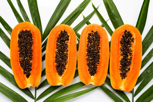 Half ripe papaya fruit on green leaves. Top view