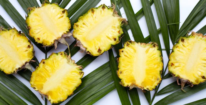Ripe pineapple on tropical palm leaves. Top view