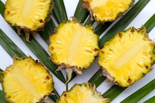 Ripe pineapple on tropical palm leaves. Top view