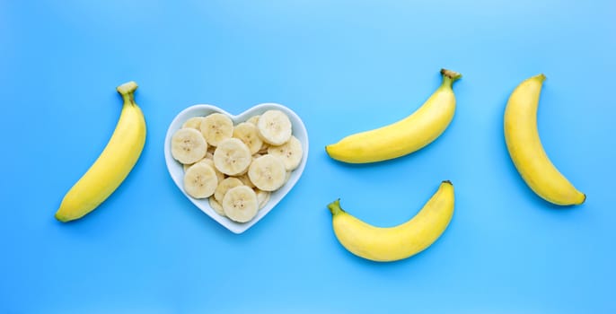Ripe yellow bananas on blue background. Top view