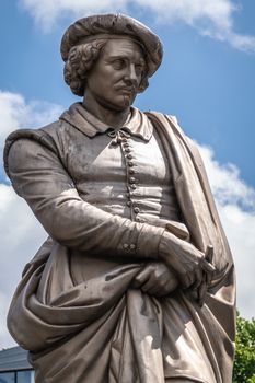 Amsterdam, the Netherlands - July 1, 2019: Closeup of beige chest and head of Rembrandt van Rijn statue on Rembrandtplein under blue sky with white clouds.