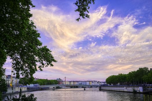 A view of Lyon, France along the Saône river at sunset.