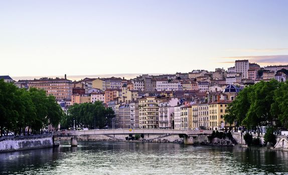 A view of Lyon, France along the Saône river at sunset.