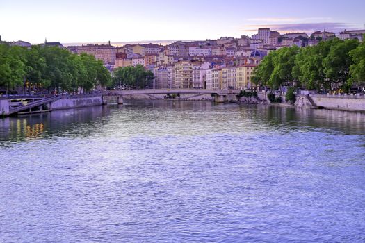 A view of Lyon, France along the Saône river at sunset.