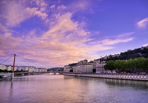 A view of Lyon, France along the Saône river at sunset.