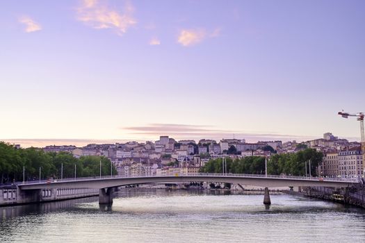 A view of Lyon, France along the Saône river at sunset.