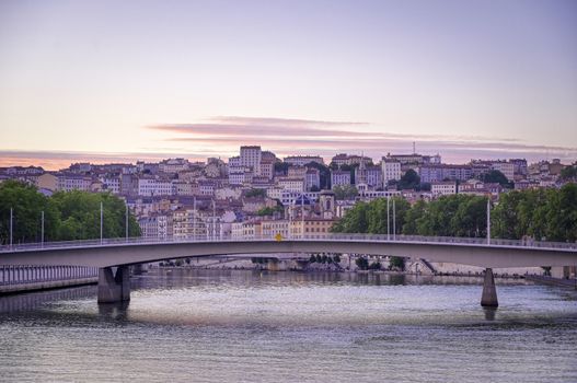 A view of Lyon, France along the Saône river at sunset.