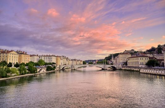 A view of Lyon, France along the Saône river at sunset.