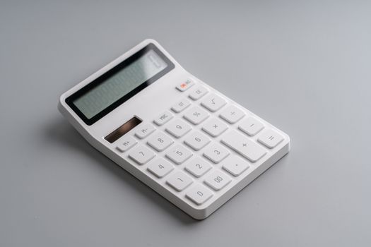 White calculator on grey background for education & business concept