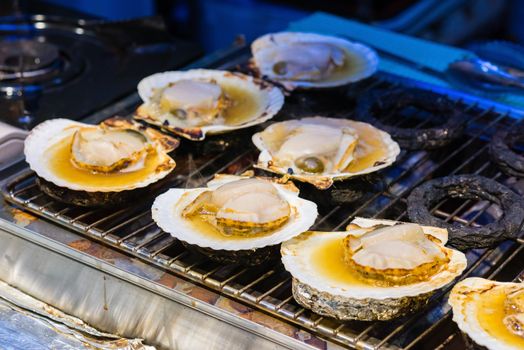 Fresh grilled scallops on the stove in street merket.