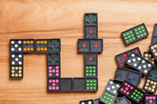 Dominoes on wooden table. Dominoes is a game played with rectangular "domino" tiles.