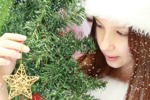 Close up portrait of the beautiful teen girl. Busy decorating Christmas tree