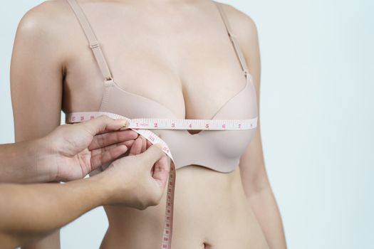 Woman measuring her chest for breast implant surgery.