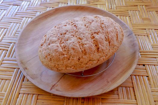 Fresh homemade bread made of wheat and rye flour. Sliced bread in a wicker basket. Bowl with salt. Delicious homemade pastries in a wicker basket. Healthy food on bamboo background.