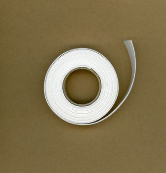 Reel of white flat strip fabric webbing