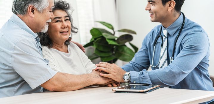 Closeup Doctor hands holding Asian grandparent patient in house for encourage, service Life insurance at home,healthcare with Long live and Elderly society,Prevent epidemic and Covid19 Disease concept