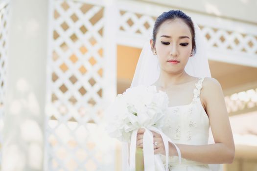 beautiful young woman on wedding day in white dress in the garden. Female portrait in the park.