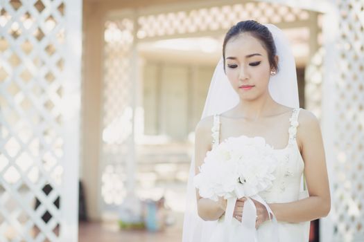 beautiful young woman on wedding day in white dress in the garden. Female portrait in the park.