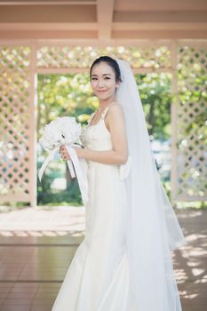 beautiful young woman on wedding day in white dress in the garden. Female portrait in the park.