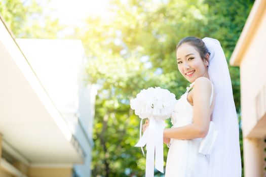 beautiful young woman on wedding day in white dress in the garden. Female portrait in the park.