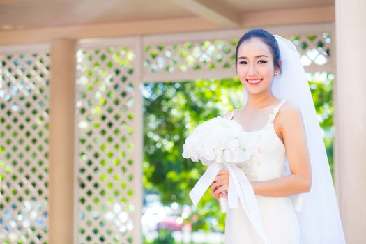 beautiful young woman on wedding day in white dress in the garden. Female portrait in the park.