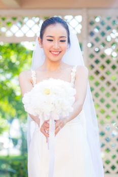 beautiful young woman on wedding day in white dress in the garden. Female portrait in the park.