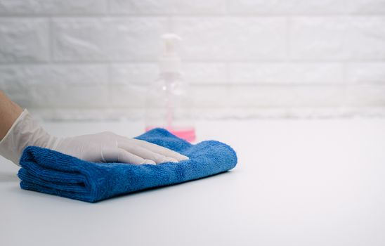 Women wearing gloves to wipe the table to clean the dust