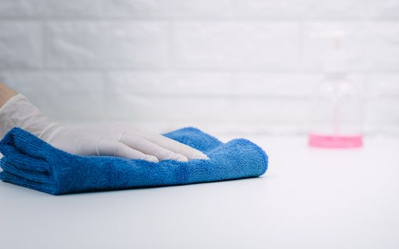 Women wearing gloves to wipe the table to clean the dust