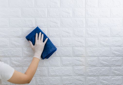 Women wearing gloves to wipe the table to clean the dust