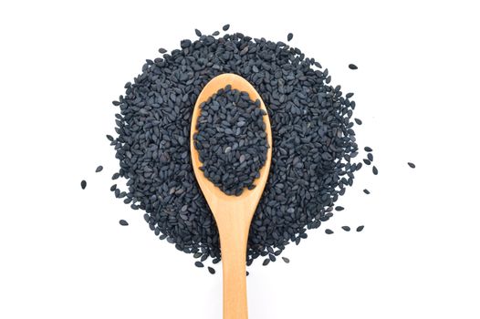 Black sesame seeds in wooden scoop on white background