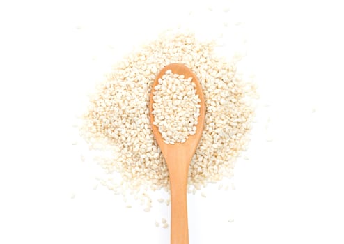 White sesame seeds in wooden scoop on white background