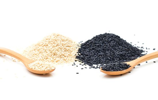 White and Black sesame seeds in wooden scoop on white background