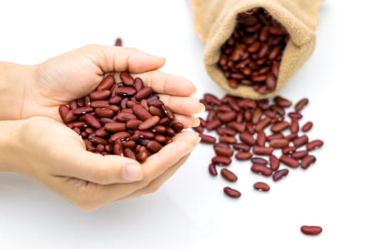 Grains Red beans in hand a sack on a white background