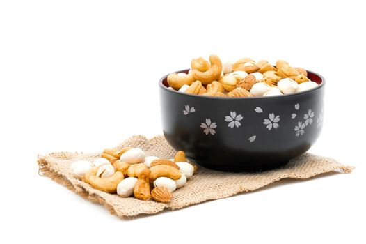 Almonds Pistachio and Cashews on a sack of cloth a white background