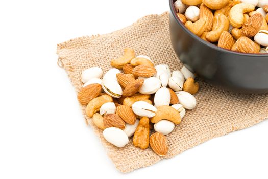 Almonds Pistachio and Cashews on a sack of cloth a white background