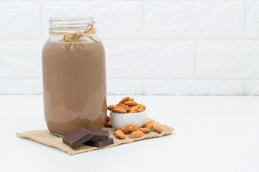 Milk Chocolate and Almonds in a glass on a white background