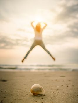 Shells on the beach female jump happy travel holiday