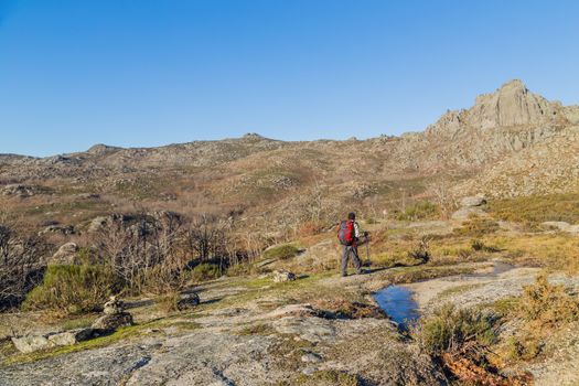 Man hiking and enjoying view of the top of a mountain in Geres, the National Park in Portugal