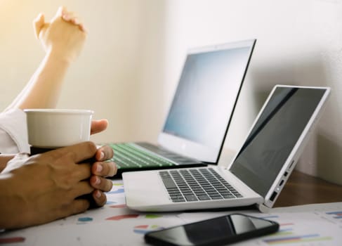 The hand that holds the coffee cup on the desk