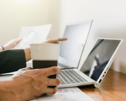 The hand that holds the coffee cup on the desk