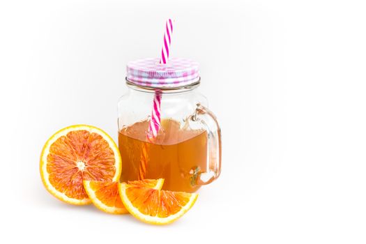 Hot orange tea in mason jar with straw, isolated on white background. Space for text.